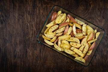 fresh raw potatoes in a baking dish, top view