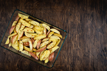 fresh raw potatoes in a baking dish, top view