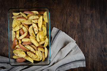 fresh raw potatoes in a baking dish, top view