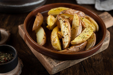 Baked potato in a plate on a wooden background, top view