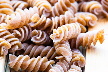 raw pasta with wooden spoons