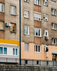 Fototapeta na wymiar man painting a facade of an old building