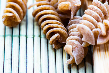 raw pasta with wooden spoons
