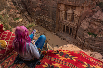 top view travel photography of touristic girl with pink hair sit on edge of cliff back to camera...