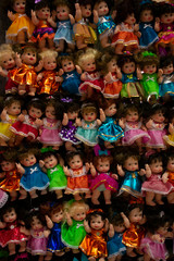Muñecas de juguete, hechas de plástico y con coloridos vestidos, exhibidas en un típico mercado de mexico