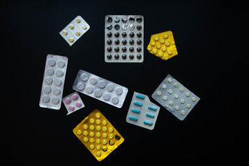 packages of medicine pills, black background, flat lay