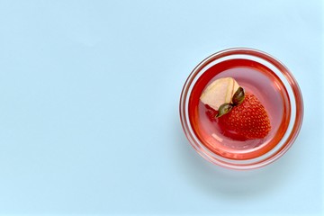 Jelly with strawberries, apples and basil in a transparent rosette. Right on a blue background, a view from above, the berry is diagonal.
