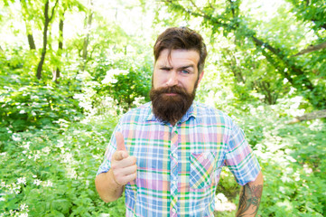 Hey, look. Bearded man pointing finger before him on natural landscape. Brutal hipster pointing...