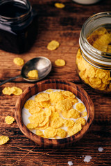Breakfast with corn flakes, milk and berry syrup