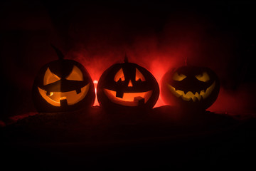 Group of Halloween Jack o Lanterns at night with a rustic dark foggy toned background