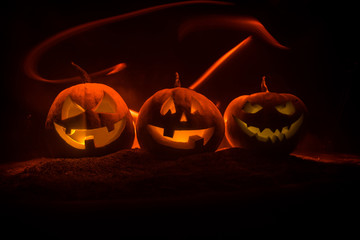 Group of Halloween Jack o Lanterns at night with a rustic dark foggy toned background