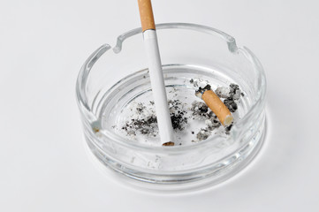 Cigarette in ashtray isolated on white background