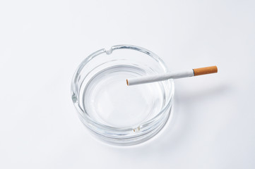 Cigarette in ashtray isolated on white background
