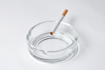 Cigarette in ashtray isolated on white background