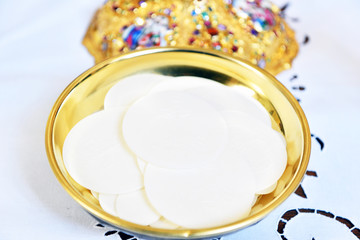 Golden paten with white hosties.