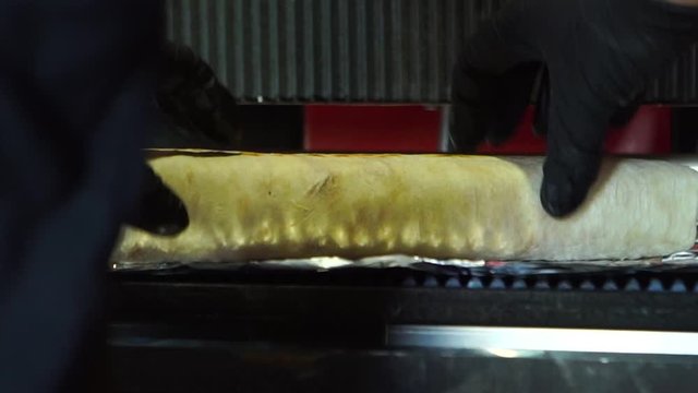 Chief hands wrapping traditional shawarma roll with meat and vegetables