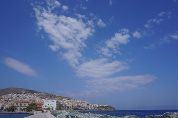 Fototapeta premium Hermoupolis, Syros, Greece: View from the breakwater of a cloud formation over the coast of Syros, a Cyclades Island in Greece.