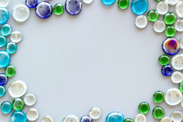Pattern from colored glass stones on gray background top view mockup