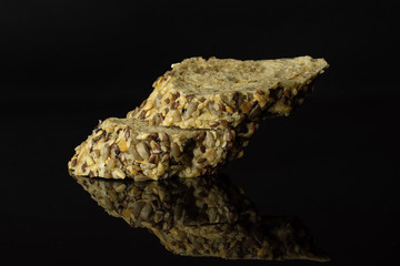Group of two slices of crispy fresh cereal baguette isolated on black glass