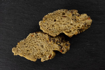 Group of two slices of fresh cereal baguette flatlay on grey dark stone