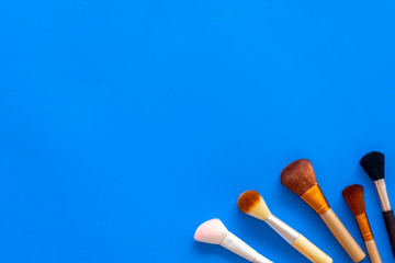 Instruments for make up with brushes on blue background top view mock up