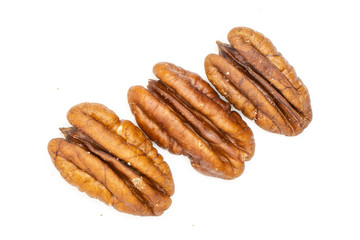 Group of three whole unshelled fresh brown pecan nut half flatlay isolated on white background