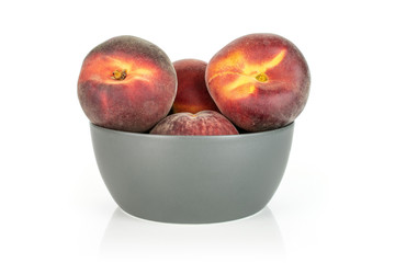 Group of four whole fresh red peach in a gray ceramic bowl isolated on white background