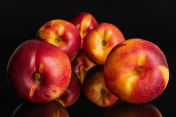 Group of five whole fresh red nectarine isolated on black glass