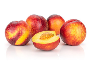 Group of four whole one half of fresh red nectarine isolated on white background