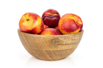 Lot of whole fresh red nectarine in a big wooden bowl isolated on white background