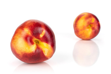 Group of two whole fresh red nectarine one is in the front isolated on white background