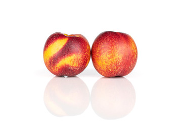 Group of two whole fresh red nectarine close together isolated on white background