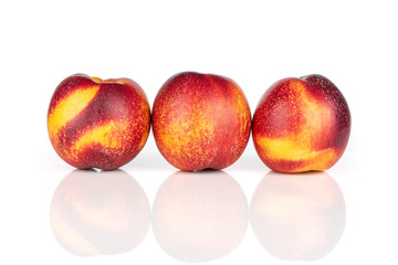 Group of three whole fresh red nectarine in a row isolated on white background