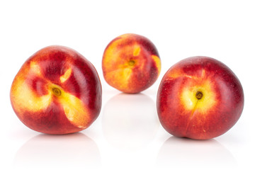 Group of three whole fresh red nectarine two are in the front isolated on white background