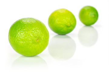 Group of three whole fresh green lime placed diagonally in a line isolated on white background