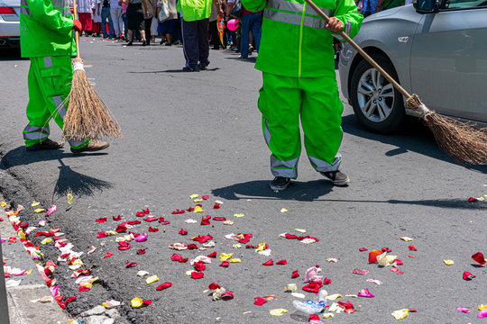 Barrendero con su uniforme y su escoba rústica hecha con ramas secas de árbol,  barriendo la basura de la calle en México