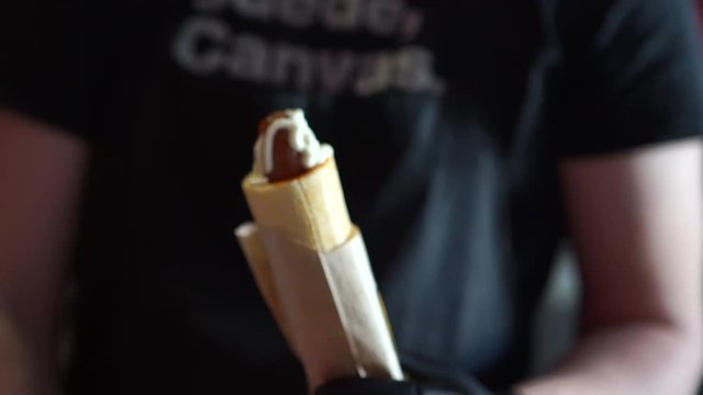 Hotdog - friendly chef preparing fresh ingredients in a fast food snack bar