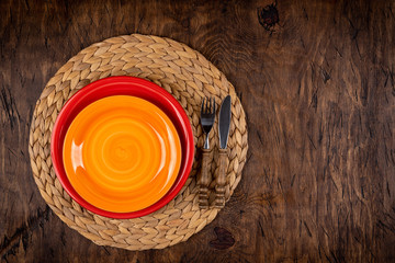 Empty plate with fork and knife on colored wooden background, top view, copy space, mock-up