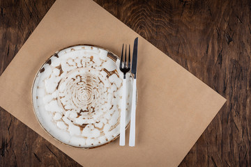 Empty plate with fork and knife on colored wooden background, top view, copy space, mock-up