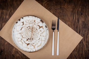 Empty plate with fork and knife on colored wooden background, top view, copy space, mock-up