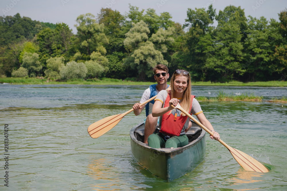 Wall mural couple of explorers conoining on wild river