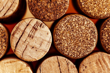 Wine corks side by side in a pile macro close-up background. The used red wine corks display...