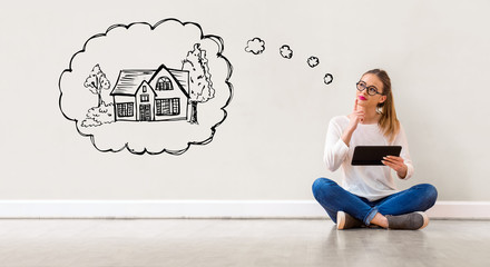 Dreaming of new home with young woman holding a tablet computer