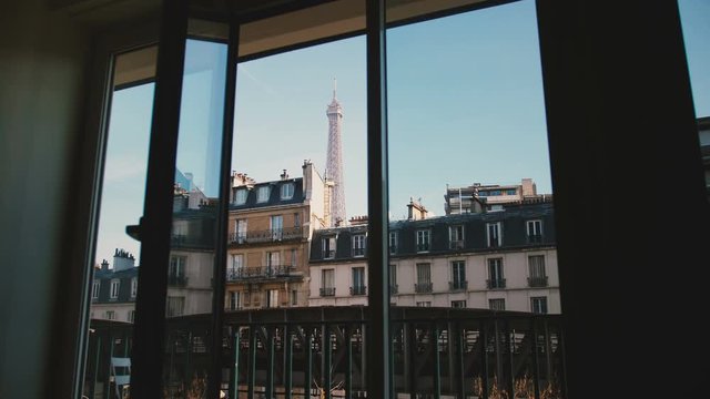 Peaceful sunny morning view of iconic Eiffel Tower in Paris through open apartment window, travel and romance concept.