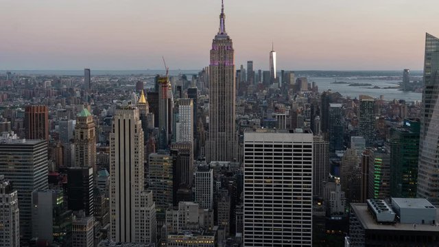 NEW YORK CITY, USA - June 2019: Beautiful sunset from top of Rockefeller Center. New York City panoramic time lapse with Empire State Building as main focus.