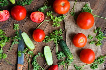 vegetables - tomatoes and cucumbers on a wooden board.