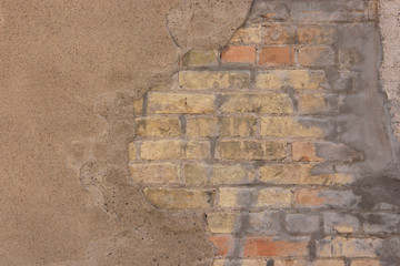 old brick wall with cracks and plaster