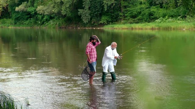 Father and son ishing. Generations ages: grandfather and father. Grandfather and boy fishing together. Happy family concept - father and son together. Portrait of cheerful two bearded men fishing.