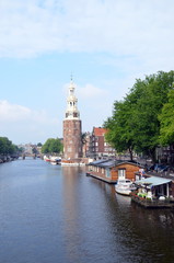 Fototapeta premium The Montelbaanstoren tower on Oudeschans canal in Amsterdam, Netherlands, built in 1516 for the purpose of defending the city 
