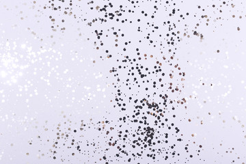 Champagne gold confetti sparkles on cold grey background.